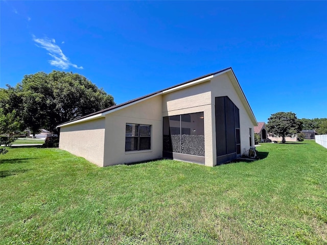 back of property with a lawn and a sunroom