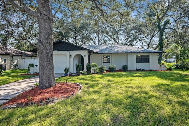 ranch-style home with a garage and a front lawn