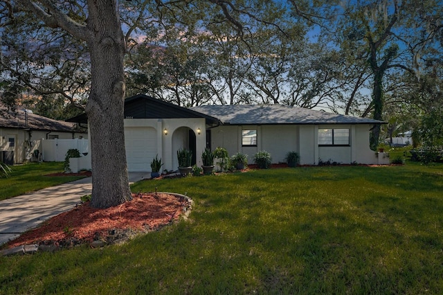 ranch-style house featuring a front yard and a garage