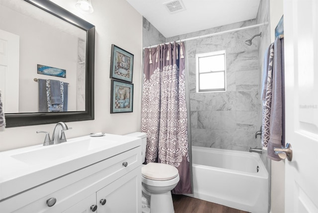 full bathroom with hardwood / wood-style floors, shower / tub combo with curtain, vanity, and toilet