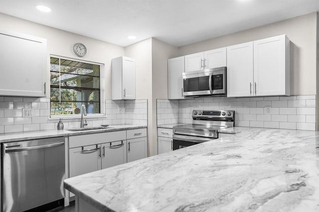 kitchen featuring white cabinetry, appliances with stainless steel finishes, tasteful backsplash, and sink