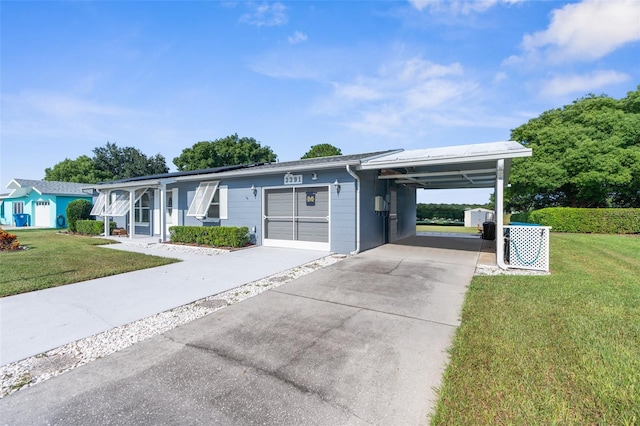 single story home featuring a front lawn, a carport, and a garage