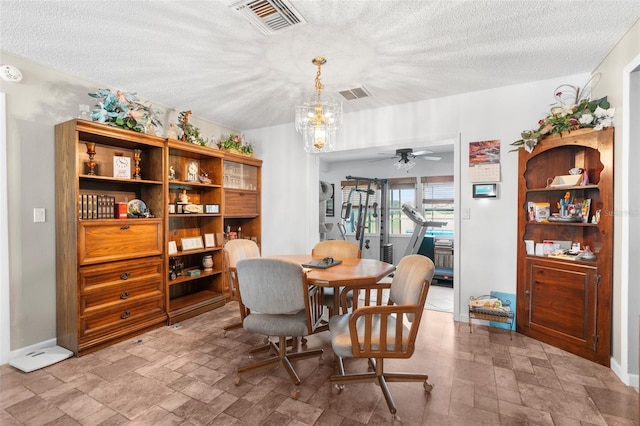 dining room featuring a textured ceiling and ceiling fan with notable chandelier