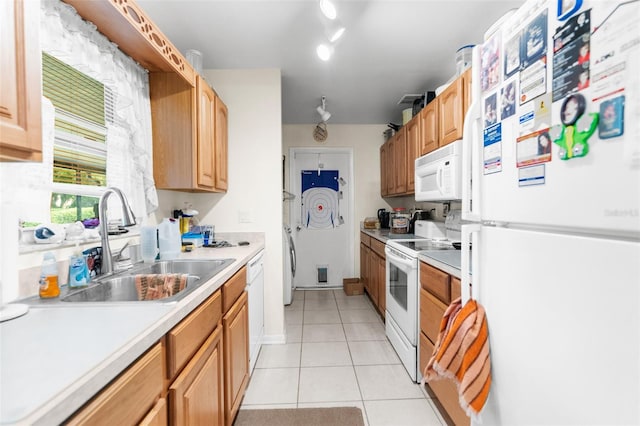 kitchen with light tile patterned flooring, sink, white appliances, and washer / dryer