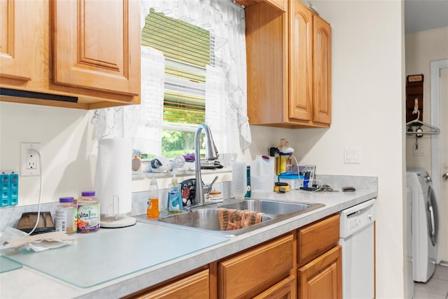 kitchen featuring white dishwasher, sink, and washer and dryer