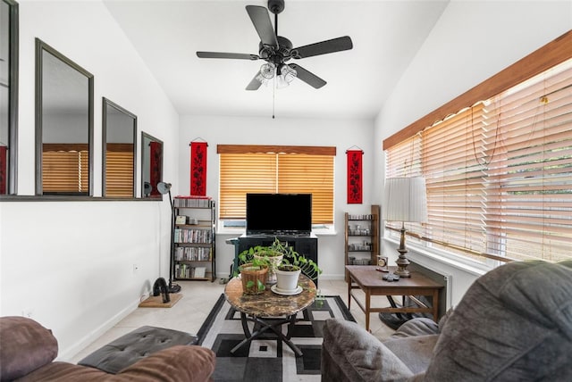 living room featuring ceiling fan, light tile patterned floors, and vaulted ceiling