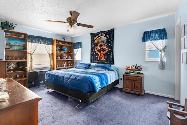 bedroom with dark colored carpet, ceiling fan, and a textured ceiling