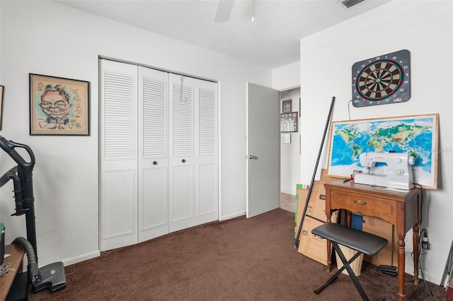 interior space with dark colored carpet, ceiling fan, and a textured ceiling