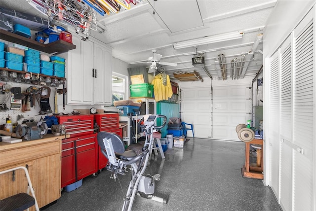 garage featuring a garage door opener, a workshop area, and ceiling fan