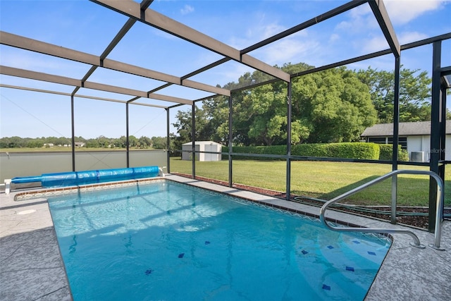 view of pool featuring glass enclosure, a storage shed, and a yard