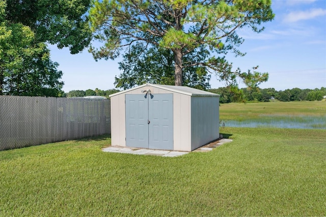 view of outdoor structure with a lawn and a water view