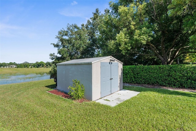 view of outbuilding featuring a lawn and a water view