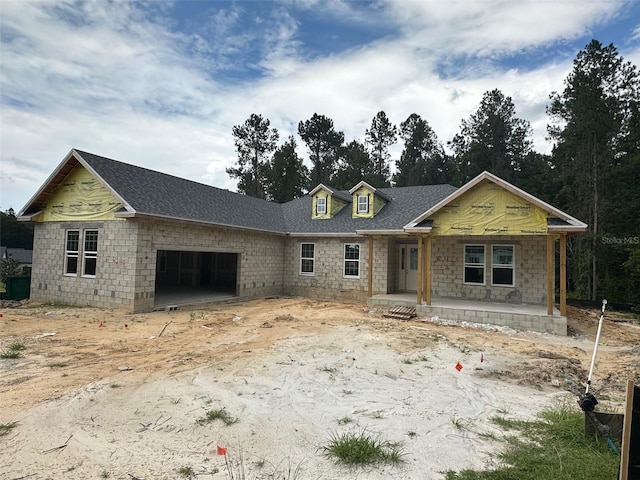 unfinished property with a garage and covered porch