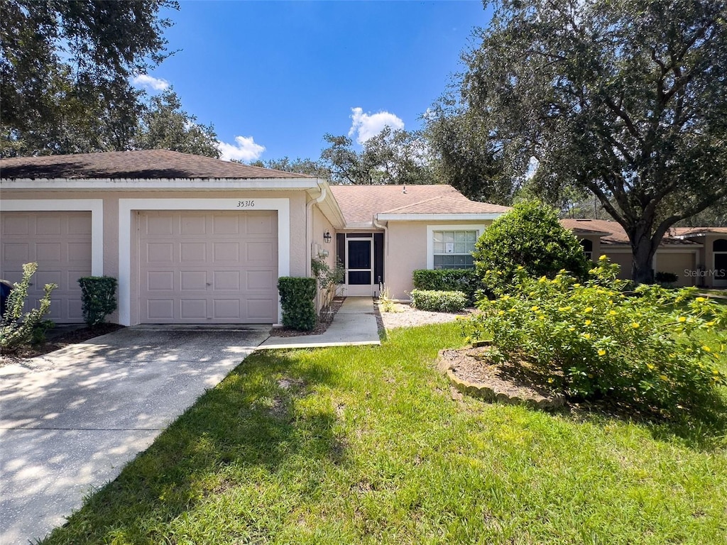 ranch-style house featuring a front lawn and a garage