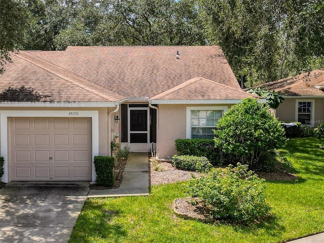 ranch-style home featuring a garage and a front lawn