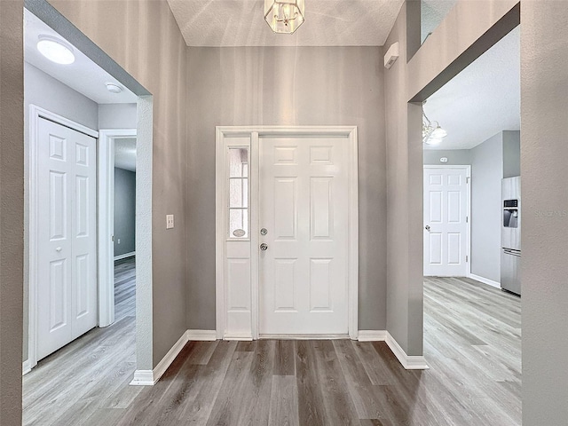 entrance foyer with a chandelier, a textured ceiling, and hardwood / wood-style flooring