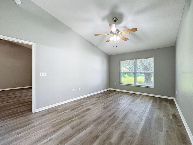 spare room with ceiling fan, hardwood / wood-style flooring, vaulted ceiling, and a textured ceiling