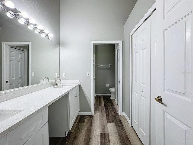 bathroom with vanity, toilet, and hardwood / wood-style flooring