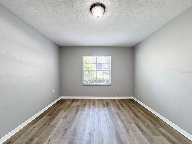 unfurnished room featuring a textured ceiling and light wood-type flooring