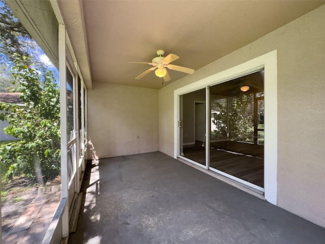 unfurnished sunroom featuring ceiling fan