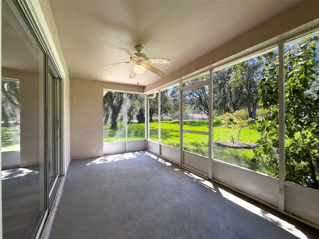 unfurnished sunroom featuring ceiling fan