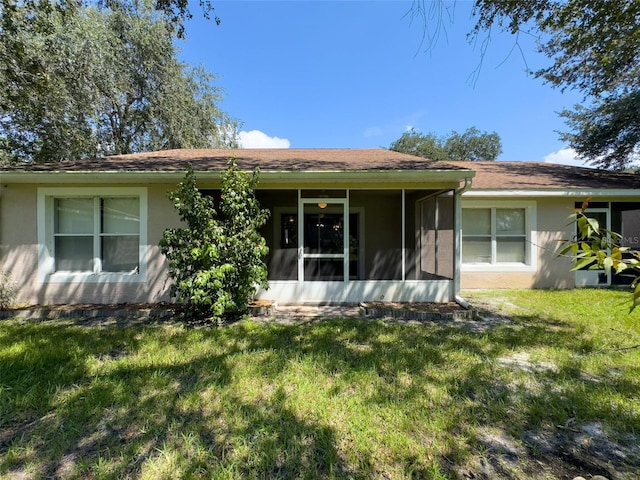 single story home featuring a front lawn and a sunroom