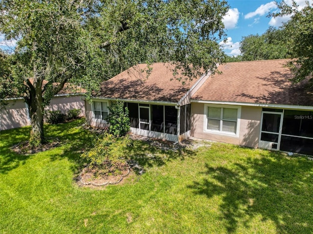 rear view of house with a sunroom and a yard