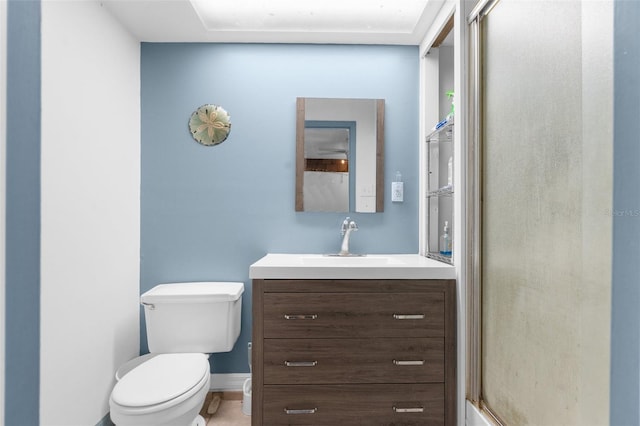 bathroom featuring vanity, toilet, and an enclosed shower