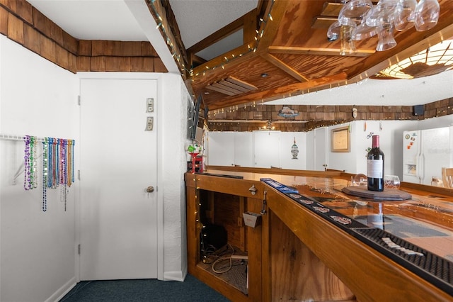 bar featuring carpet, white cabinets, and white fridge with ice dispenser