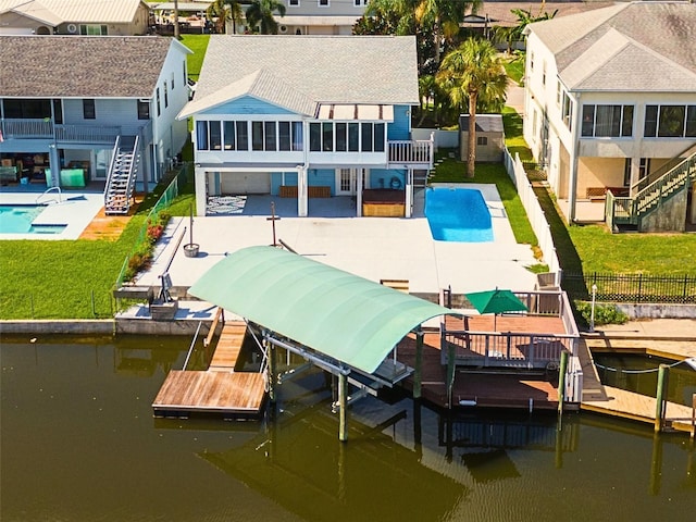 view of dock with a pool side deck with water view, a yard, and a patio area