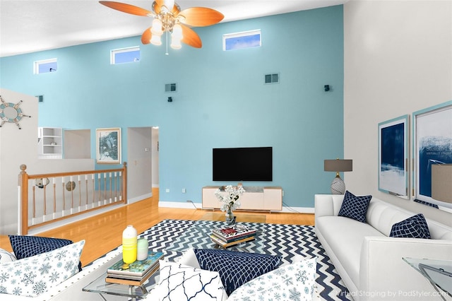 living room featuring a high ceiling, ceiling fan, and hardwood / wood-style flooring