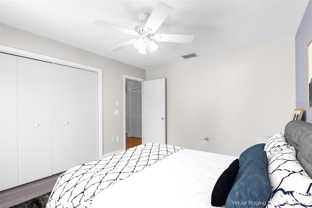 bedroom featuring ceiling fan, a closet, and dark hardwood / wood-style flooring