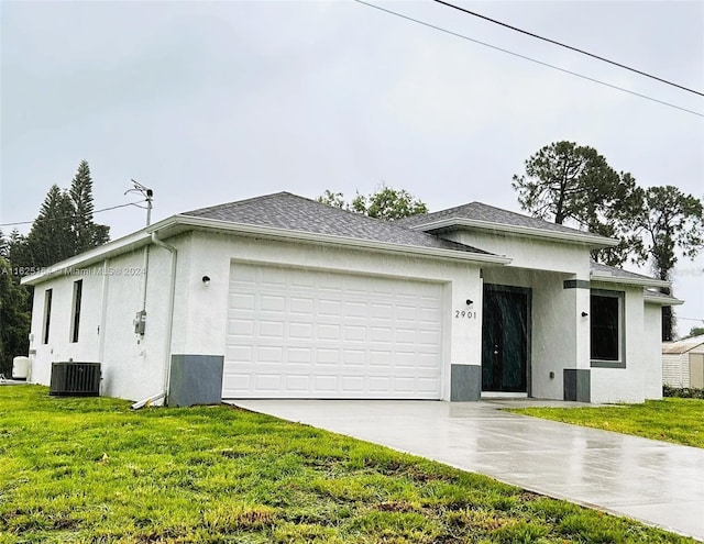 ranch-style house with a front yard, central air condition unit, and a garage