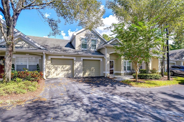 view of front of house featuring aphalt driveway, stucco siding, and a garage