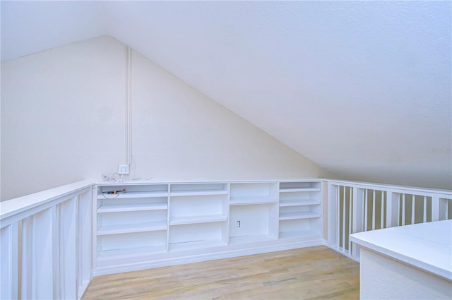 additional living space with lofted ceiling and light hardwood / wood-style floors