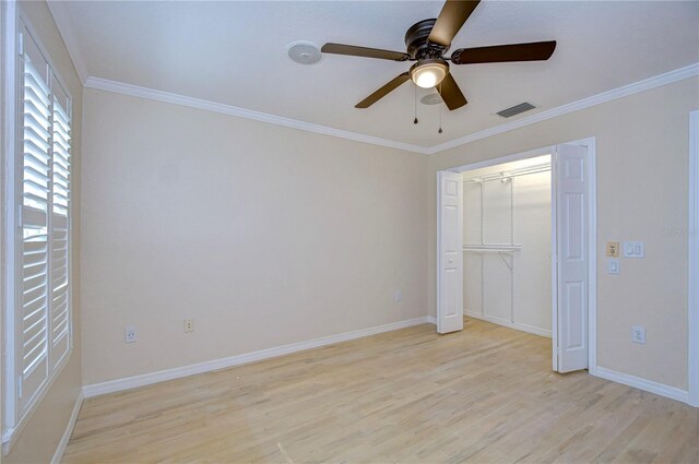 unfurnished bedroom with crown molding, light hardwood / wood-style floors, a closet, and ceiling fan