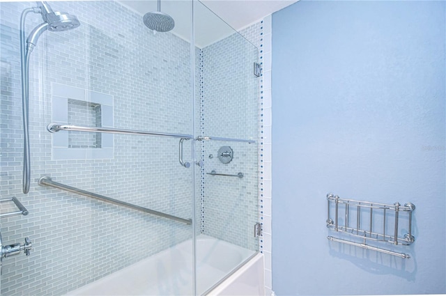 bathroom with shower / bath combination with glass door