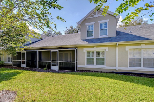 rear view of property with a sunroom and a yard