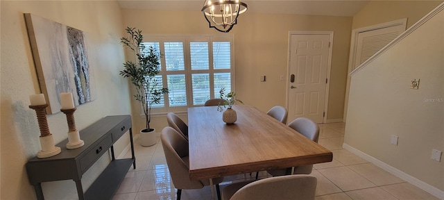 dining space with light tile patterned flooring and a notable chandelier