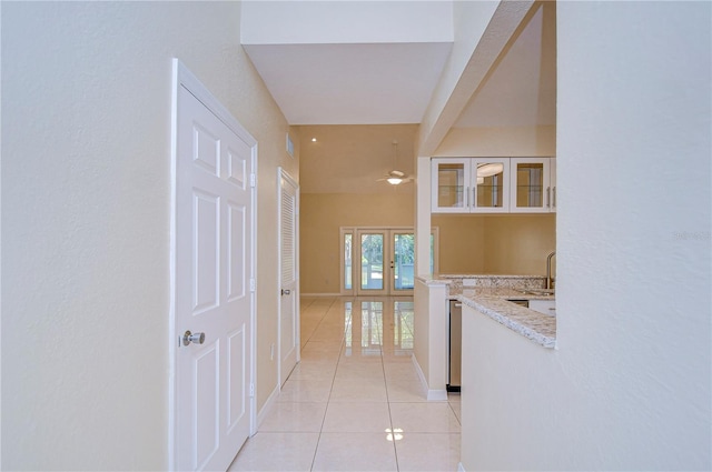 corridor with sink, french doors, and light tile patterned flooring