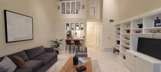 living room featuring a high ceiling and light tile patterned floors