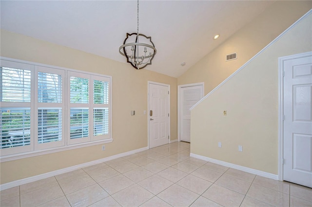 tiled foyer with an inviting chandelier and vaulted ceiling