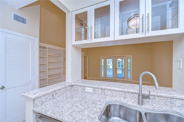 kitchen featuring light stone counters and sink