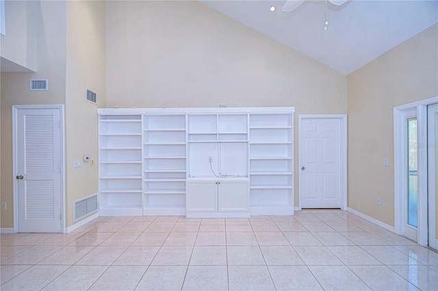 interior space featuring light tile patterned flooring and high vaulted ceiling