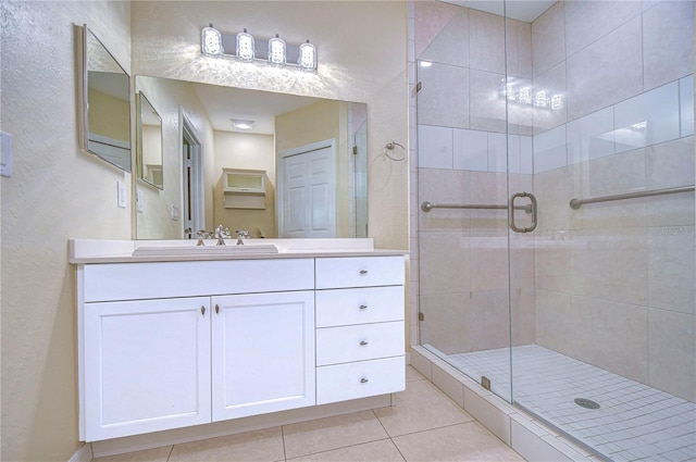 bathroom with vanity, an enclosed shower, and tile patterned floors