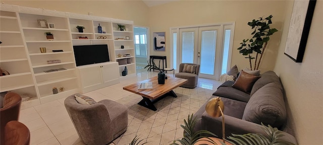 living room featuring lofted ceiling, light tile patterned floors, and french doors