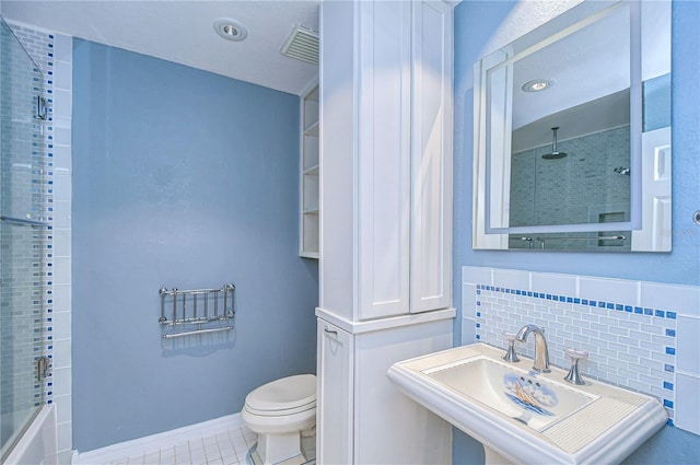 full bathroom with sink, decorative backsplash, tile patterned flooring, enclosed tub / shower combo, and toilet