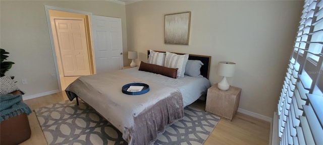 bedroom with light wood finished floors and baseboards