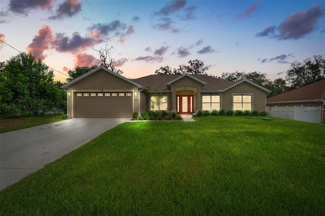 ranch-style home with a garage and a yard