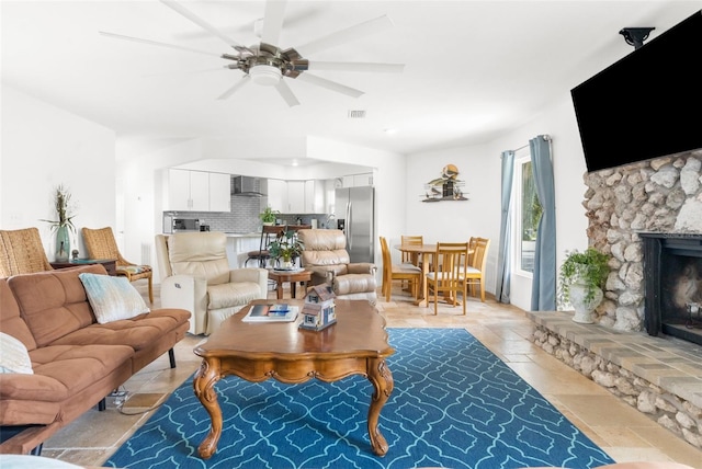 living room featuring ceiling fan and a fireplace